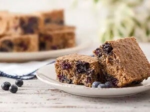 Pedaço de Bolo Integral de Banana e Blueberry, sem Açúcar e sem Lactose em um prato branco