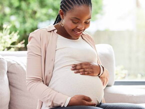 gestante sentada com as mãos na barriga