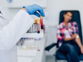 Mulher manuseando tubos de ensaio com amostras de sangue