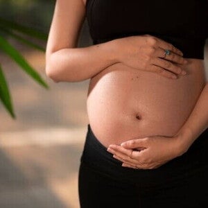 Mulher grávida com as mãos sobre a barriga Mulher grávida com as mãos sobre a barriga