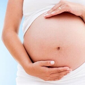 Mulher grávida com as mãos envolvendo a barriga