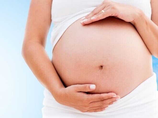 Mulher grávida com as mãos envolvendo a barriga Mulher grávida com as mãos envolvendo a barriga