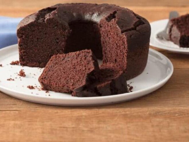 Bolo de chocolate com cobertura disposto sobre um prato branco Bolo de chocolate com cobertura disposto sobre um prato branco