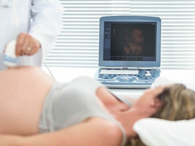 Imagem de uma gestante em um ambiente hospitalar fazendo exame de translucência nucal Imagem de uma gestante em um ambiente hospitalar fazendo exame de translucência nucal