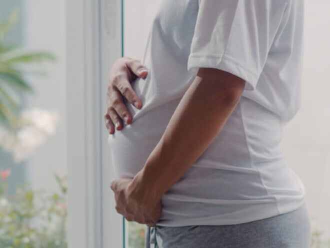 imagem de uma mulher grávida usando uma camiseta branco, com maior foco na barriga imagem de uma mulher grávida usando uma camiseta branco, com maior foco na barriga