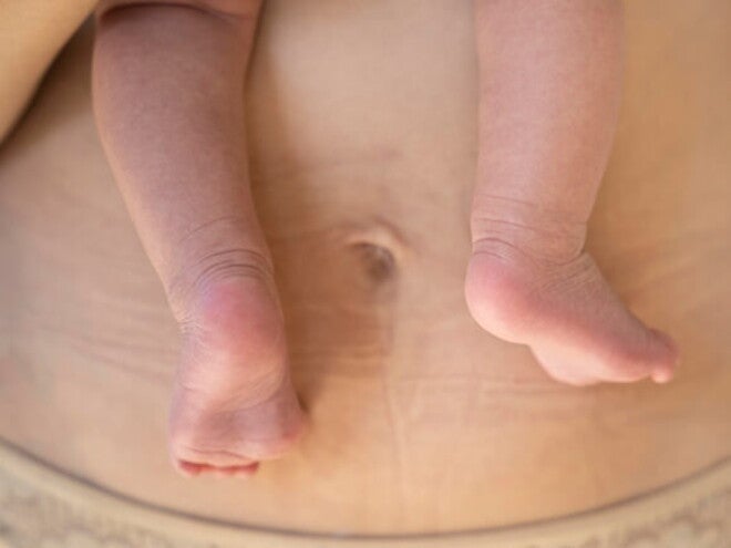 Mãe com recém-nascido no colo vestindo uma calcinha pós-parto Mãe com recém-nascido no colo vestindo uma calcinha pós-parto