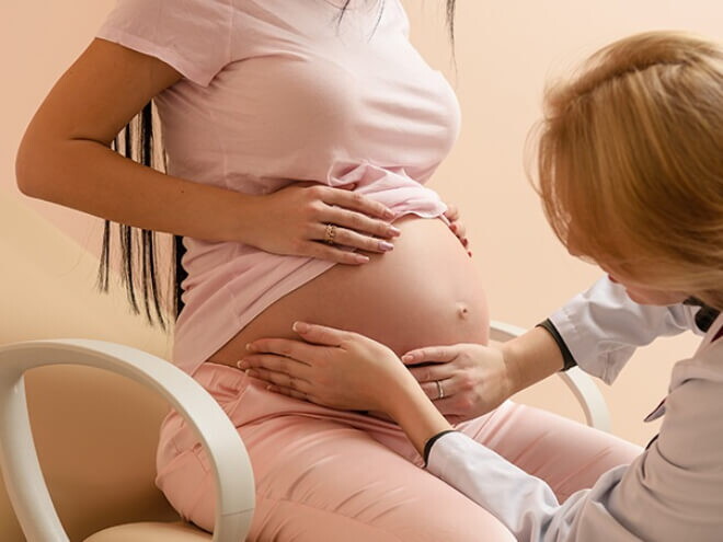 Médica obstetra apalpando a barriga de uma mulher grávida Médica obstetra apalpando a barriga de uma mulher grávida