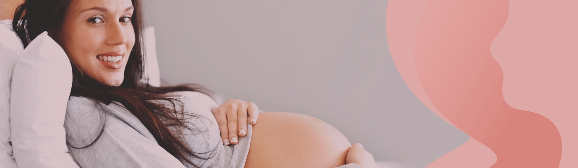 Pregnant woman reclined on her bed wtih some pillows, looking and smiling at the camera. Pregnant woman reclined on her bed wtih some pillows, looking and smiling at the camera.
