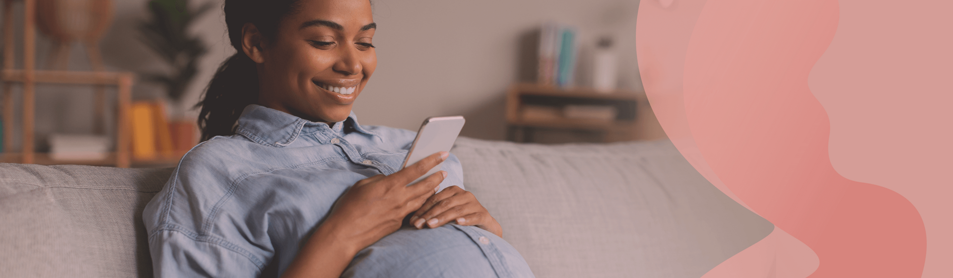 Pregnant woman sitting on a couch, looking at her smarphone and smiling. Pregnant woman sitting on a couch, looking at her smarphone and smiling.