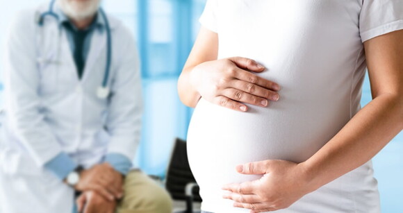 gestante no consultório médico com as mãos sobre a barriga gestante no consultório médico com as mãos sobre a barriga