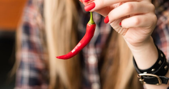 Imagem de uma mulher segurando uma pimenta vermelha Imagem de uma mulher segurando uma pimenta vermelha