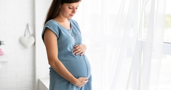grávida olhando para baixo com as mãos sobre a barriga grávida olhando para baixo com as mãos sobre a barriga
