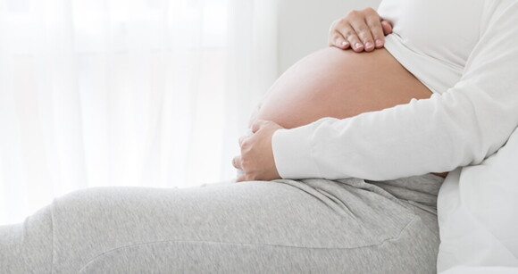 grávida sentada com as mãos sobre a barriga grávida sentada com as mãos sobre a barriga