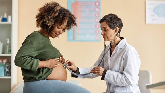 médica usando estetoscópio para examinar barriga de gestante. médica usando estetoscópio para examinar barriga de gestante.