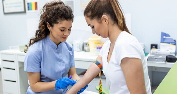 Imagem de uma enfermeira coletando amostras de sangue de uma mulher Imagem de uma enfermeira coletando amostras de sangue de uma mulher