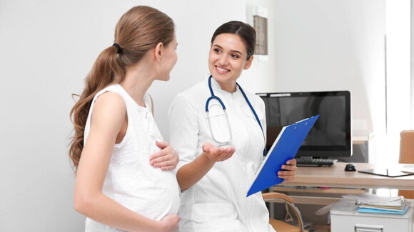 Mulher grávida conversando com uma médica Mulher grávida conversando com uma médica
