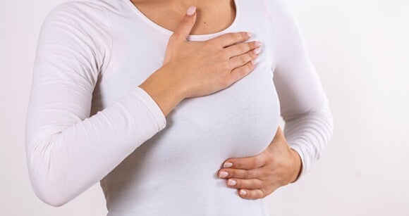 Mulher vestindo uma blusa branco apalpando os seios com as mãos Mulher vestindo uma blusa branco apalpando os seios com as mãos