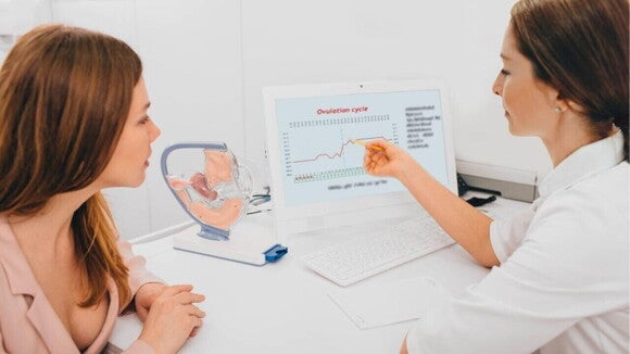 médica explicando gráfico de ovulação para paciente em consultório. médica explicando gráfico de ovulação para paciente em consultório.