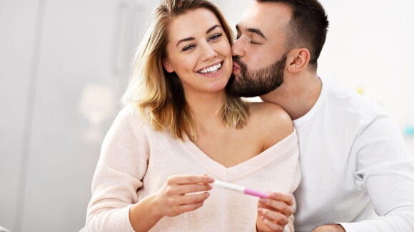 Casal feliz comemorando resultado positivo de teste de gravidez Casal feliz comemorando resultado positivo de teste de gravidez