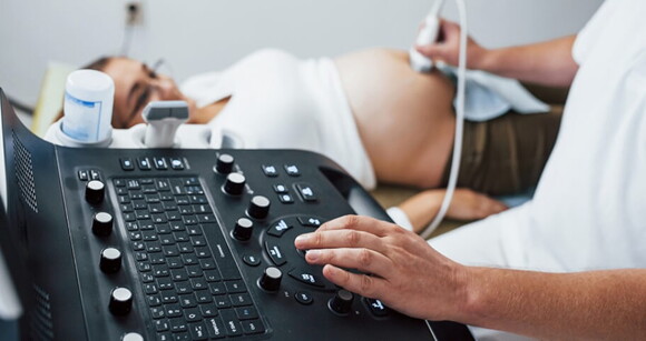 Médico fazendo exame de ultrassonografia neonatal em gestante. Médico fazendo exame de ultrassonografia neonatal em gestante.