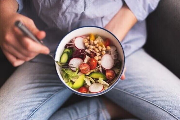 Mulher comendo alimentos ricos em ácido fólico mulher comendo vegetais e alimentos ricos em ácido fólico